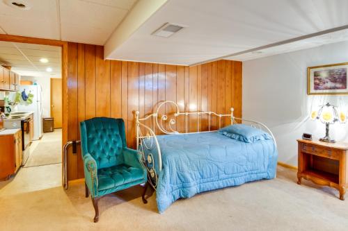 um quarto com uma cama e uma cadeira azul em Pennsylvania Countryside Retreat with Deck and Yard! em Emlenton