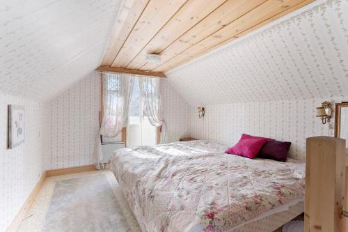 a bedroom with a bed with a pink pillow at Prästänge in Vallsta