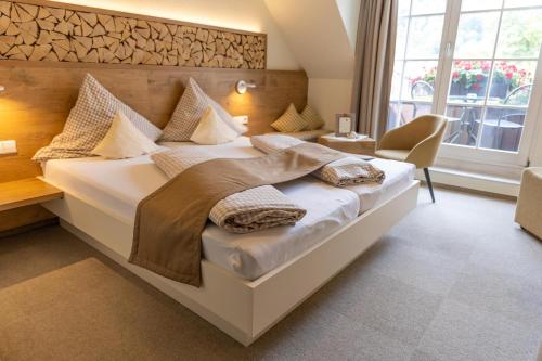 - une chambre avec un grand lit blanc et des oreillers dans l'établissement Hotel-Gasthaus Goldener Engel, à Glottertal