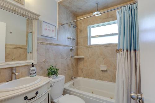 een badkamer met een bad, een toilet en een wastafel bij Stylish Updated Getaway 2 Mi to Swim and Shop! in North Palm Beach