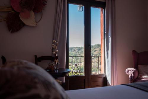 a bedroom with a bed and a window with a view at Hotel Boutique Cerro del Sol Adults only recommended in Granada