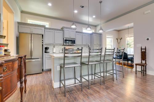 a kitchen with white cabinets and bar stools at Modern Home Less Than 1 Mi to Dwtn San Antonio and Riverwalk in San Antonio