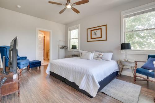 a bedroom with a bed and a television and blue chairs at Modern San Antonio Retreat Less Than 1 Mile From Downtown! in San Antonio