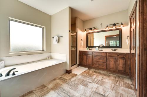 a bathroom with a tub and a sink and a mirror at Luxe Table Rock Lake Vacation Rental with Hot Tub! in Lampe
