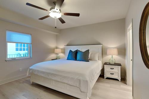 a bedroom with a white bed and a ceiling fan at Sea Glass #211 in Gulf Shores