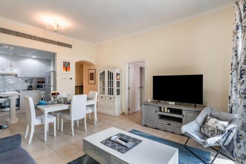 a living room with a tv and a kitchen at Lake Apartments - 1BR Apartment - Allsopp&Allsopp in Dubai