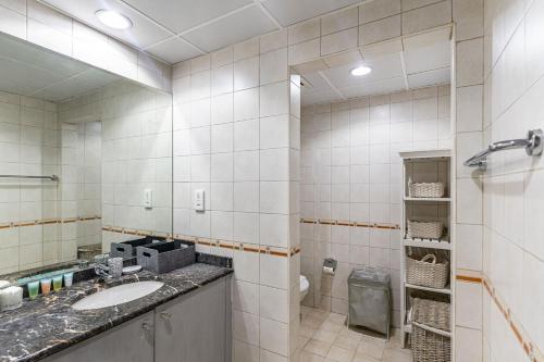 a bathroom with a sink and a mirror at Lake Apartments - 1BR Apartment - Allsopp&Allsopp in Dubai