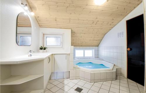 bagno con vasca e lavandino di Awesome Home In Blvand With 4 Bedrooms, Sauna And Wifi a Blåvand