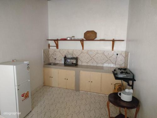 a kitchen with a refrigerator and a table in it at Manama Suites Apartment in Lamu