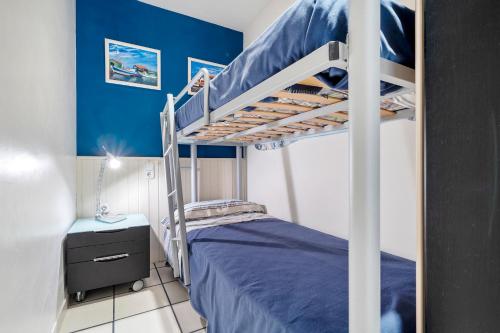 a bedroom with a bunk bed and a blue wall at Hauzify I Apartament Capellans in Salou