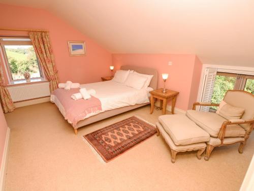 a bedroom with a bed and a chair at Garstons Barn in Newport
