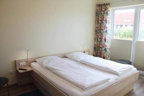a bed in a room with a window at LM 9-1-1 - Ferienwohnung Wremer Bogen Komfort in Schottwarden