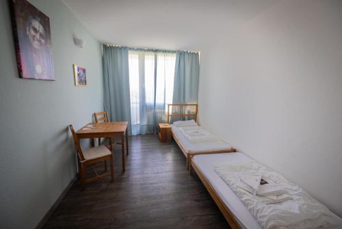 a room with two beds and a desk and a table at Hindu Monastery - Shree Peetha Nilaya Ashram in Springen