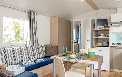 - un salon avec une table et un canapé bleu dans l'établissement Stunning Home In Hvide Sande With 2 Bedrooms, Wifi And Indoor Swimming Pool, à Hvide Sande