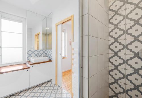 ein Bad mit einem Waschbecken und einem Spiegel in der Unterkunft la mini-Villa du Thar - jardin, plage 300m, babyfoot, arcade in Saint-Pair-sur-Mer