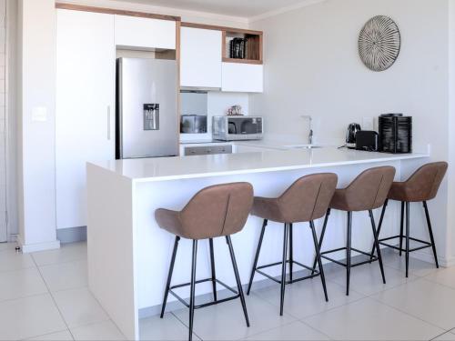 a kitchen with a counter with three stools at Masingita Towers Hotel and SPA in Johannesburg