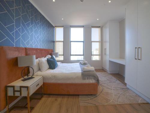 a bedroom with a bed and a table with a lamp at Masingita Towers Hotel and SPA in Johannesburg