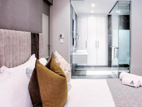 a bedroom with a bed with pillows and a bathroom at Masingita Towers Hotel and SPA in Johannesburg