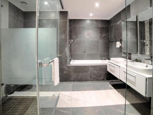 a bathroom with a shower and a tub and a sink at Masingita Towers Hotel and SPA in Johannesburg