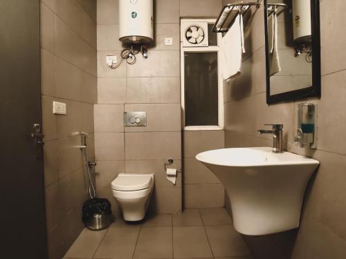 ein kleines Bad mit einem Waschbecken und einem WC in der Unterkunft Qotel Hotel La Serene Gagan Vihar Near Preet Vihar Metro Station-Couple Friendly in Neu-Delhi