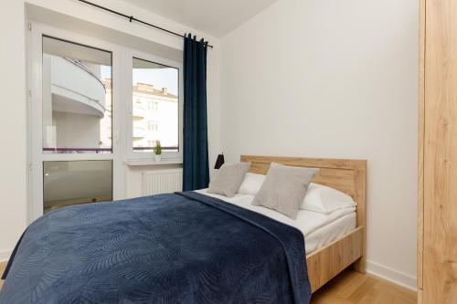 sypialnia z łóżkiem i dużym oknem w obiekcie Ursus Spacious Two-bedroom Apartment by Renters w Warszawie