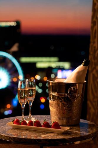 a table with two glasses of champagne and a bucket of strawberries at The Ritz-Carlton Atlanta in Atlanta