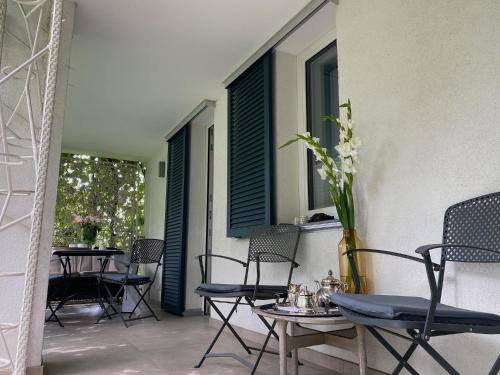 a patio with chairs and tables and windows at Casa Bella in Weinheim