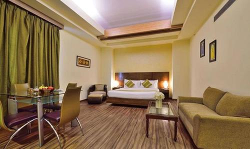 Habitación de hotel con cama, sofá y mesa en FabHotel Prime The Western en Nueva Delhi
