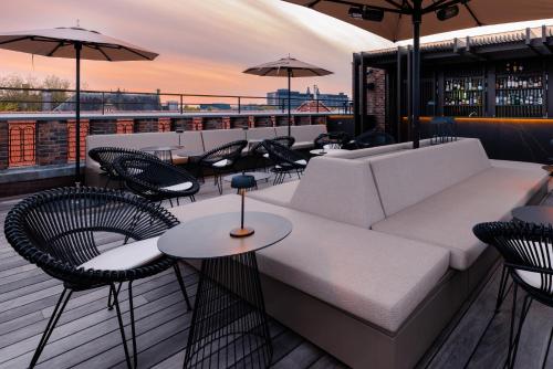 a rooftop patio with a couch and chairs and tables at Pillows Grand Boutique Hotel Maurits at the Park - Small Luxury Hotels in Amsterdam