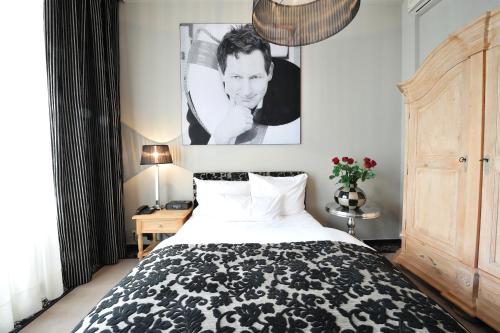 a bedroom with a bed with a black and white blanket at Stage47 in Düsseldorf
