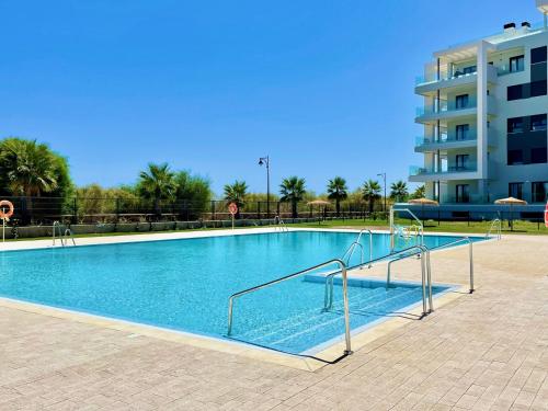 Une grande piscine avec des escaliers se trouve dans un bâtiment. dans l'établissement Residencial Camaleones by AC REAL, à Isla Canela