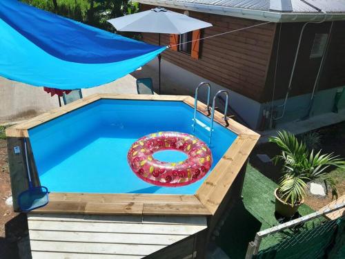 a swimming pool with a donut in the middle at Bungalow Abricot in Petit-Bourg