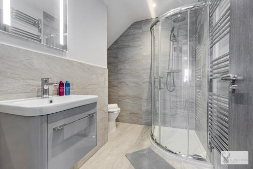 ein Bad mit einer Dusche und einem Waschbecken in der Unterkunft Silver Stag, Glamorous 5 BR House in Smisby