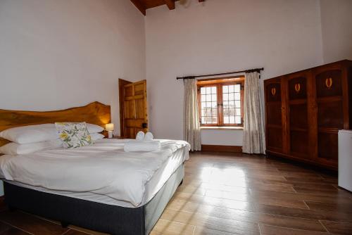 a bedroom with a large bed and a window at Heins Manor House in Stellenbosch