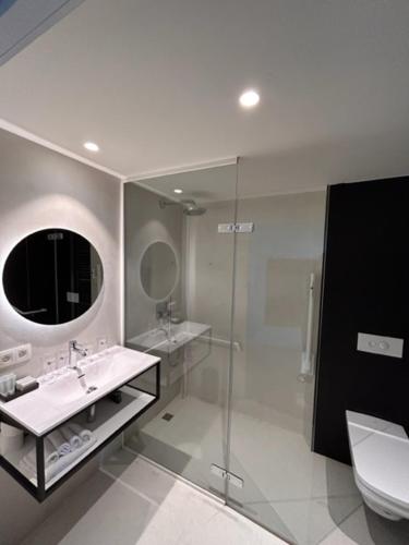 uma casa de banho com um lavatório, um WC e um espelho. em Hotond Sporthotel em Kluisbergen
