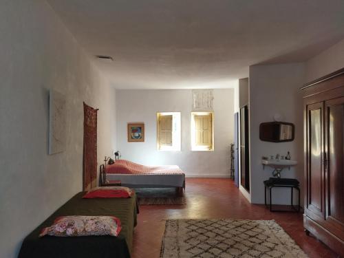 Cet appartement comprend une chambre avec un lit et une télévision. dans l'établissement Le Palazzo d'Orgon - chambre d'hôtes dans les Alpilles, à Orgon