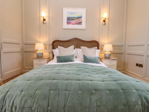 una camera da letto con un grande letto verde con due lampade di The Pavillion a Carlisle
