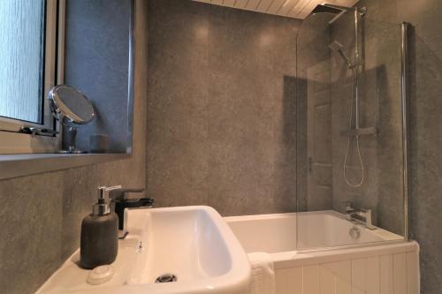 a bathroom with a sink and a shower at Signature - Carrick View in Cumbernauld