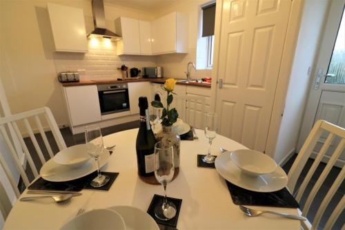 a dining room table with a bottle of wine and glasses at Signature - Carrick View in Cumbernauld