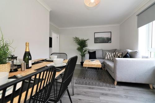 a living room with a couch and a table at Signature - Caldercruix House in Caldercruix