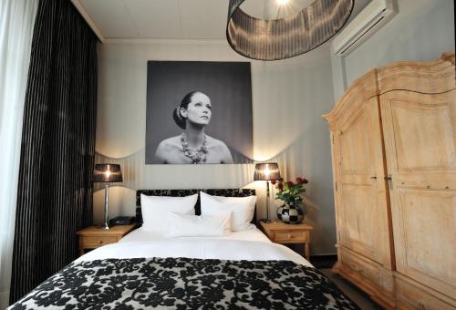 a bedroom with a bed and a portrait of a woman at Stage47 in Düsseldorf