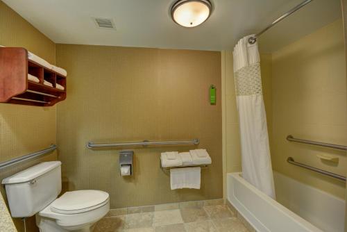 Hampton Inn Indianapolis-South في Southport: حمام مع مرحاض وحوض استحمام ودش