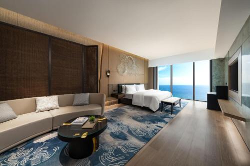 a living room with a couch and a bed at The Westin Yantai in Yantai