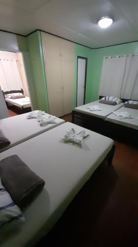 duas camas num quarto com paredes verdes em Dion's Place em Iloilo