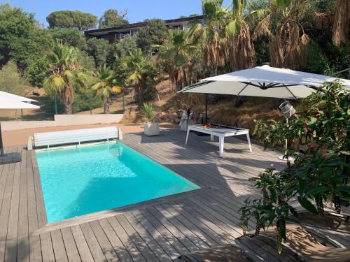 - une piscine avec un parasol et une table dans l'établissement Appartement - Maison 