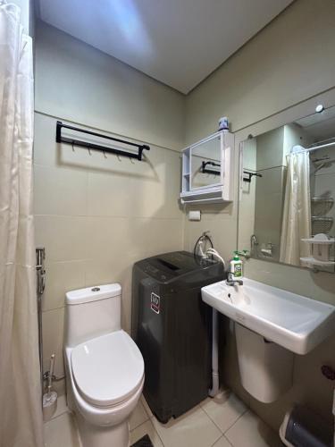 La salle de bains est pourvue de toilettes blanches et d'un lavabo. dans l'établissement Your Home@MOA*Airports*Jacuzzi*FastWiFi*Netflix, à Manille