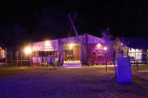 a house with a windmill at night at Chanaka Eco Camp ( Adventure Assam ) in Pakariāmukh