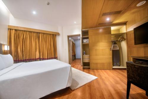 sypialnia z dużym białym łóżkiem i kuchnią w obiekcie Marigold Hotel w mieście Hajdarabad