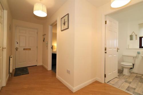 a bathroom with a toilet and a hallway at Signature - Douglas View Blantyre in High Blantyre