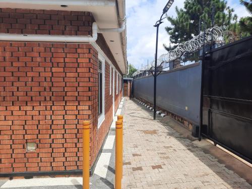 a red brick wall next to a train station at Deerwood Family Apartments, Bulenga in Bulenga